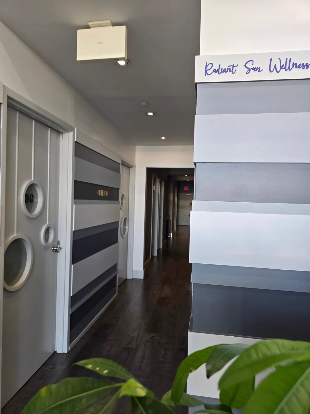 The Radiant Sun Wellness name lettered on the striped wall at the entrance to the treatment hallway.
