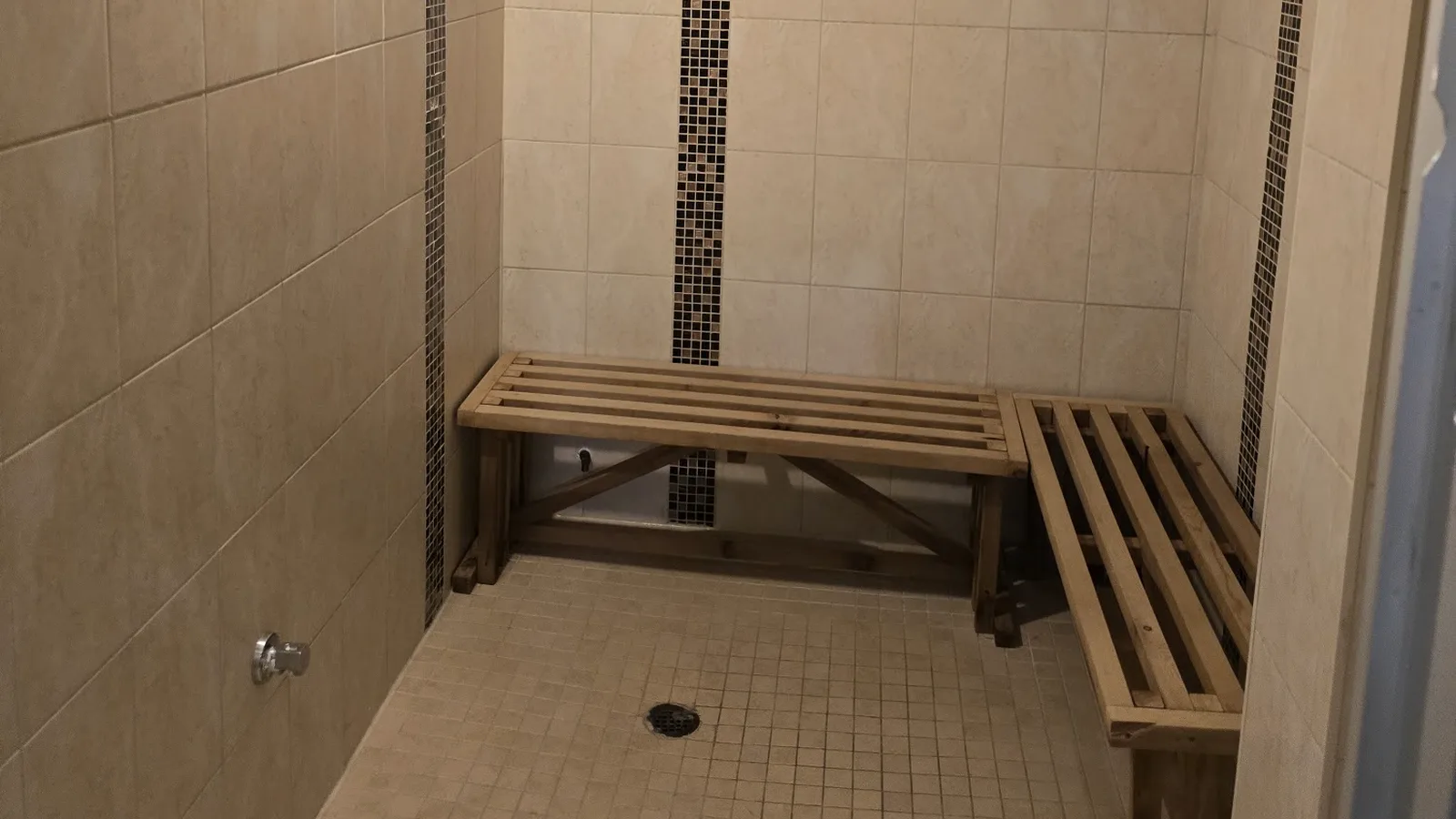 The tiled steam room at Radiant Sun Wellness, with cedar benches along two walls.