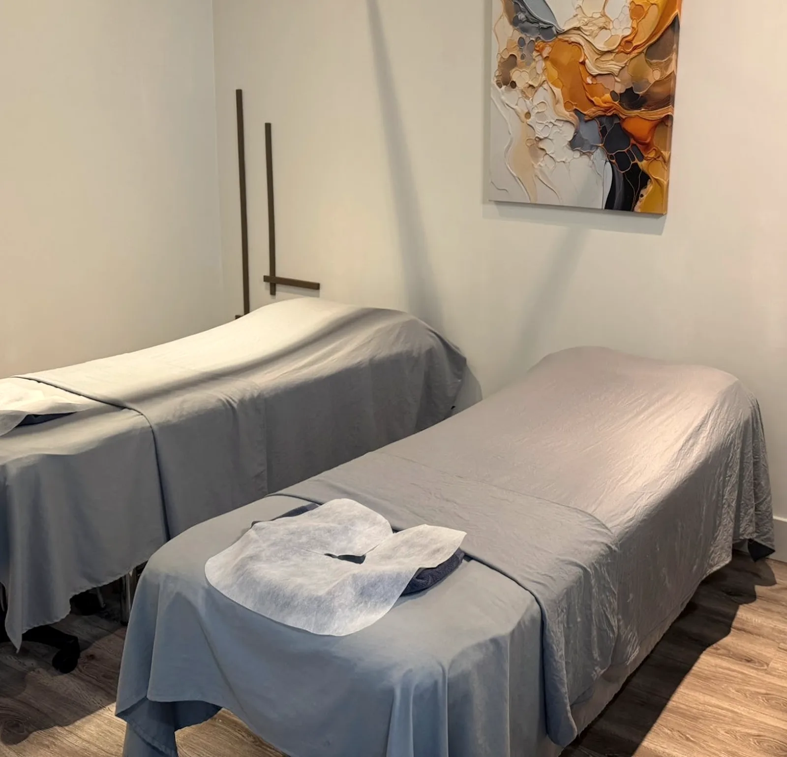 A private treatment room with two massage beds made up with fresh linens.